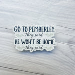 A die-cut sticker with the quote 'GO TO PEMBERLEY, they said HE WON'T BE HOME, they said' in navy and gray lettering with small green floral accents, displayed on a light gray wood plank background.
