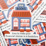 A pile of die-cut educational stickers shaped like bookstores, featuring the word 'BOOKS' on the roof and the phrase 'time to make poor financial choices in a bookstore' on the sign. The stickers are printed in a retro palette of dusty blue, terracotta orange, and white, with black outlines and text.