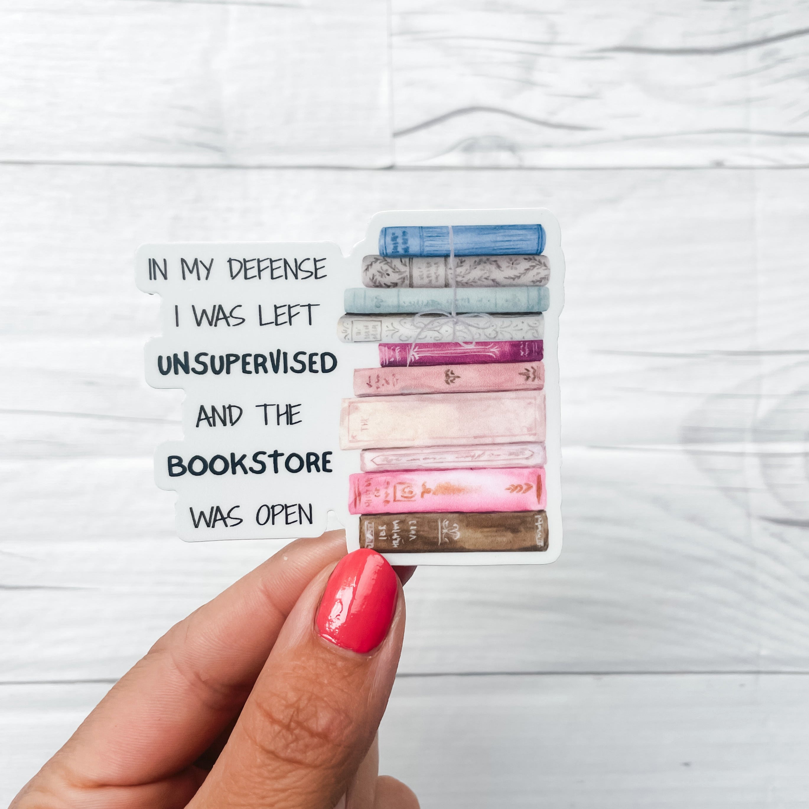 Sticker with a stack of books the the quote "in my defense i was left unsupervised and the bookstore was open"