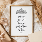 A framed typographic art print with a black crown illustration and the quote 'perhaps you were born for such a time as this.' in black script, styled on beige paper with dried grasses, a wrapped gift, and a ribbon.
