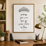 A framed typographic wall art print hangs on a beige wall above a wooden desk. The print features a black crown illustration and the quote 'perhaps you were born for such a time as this.